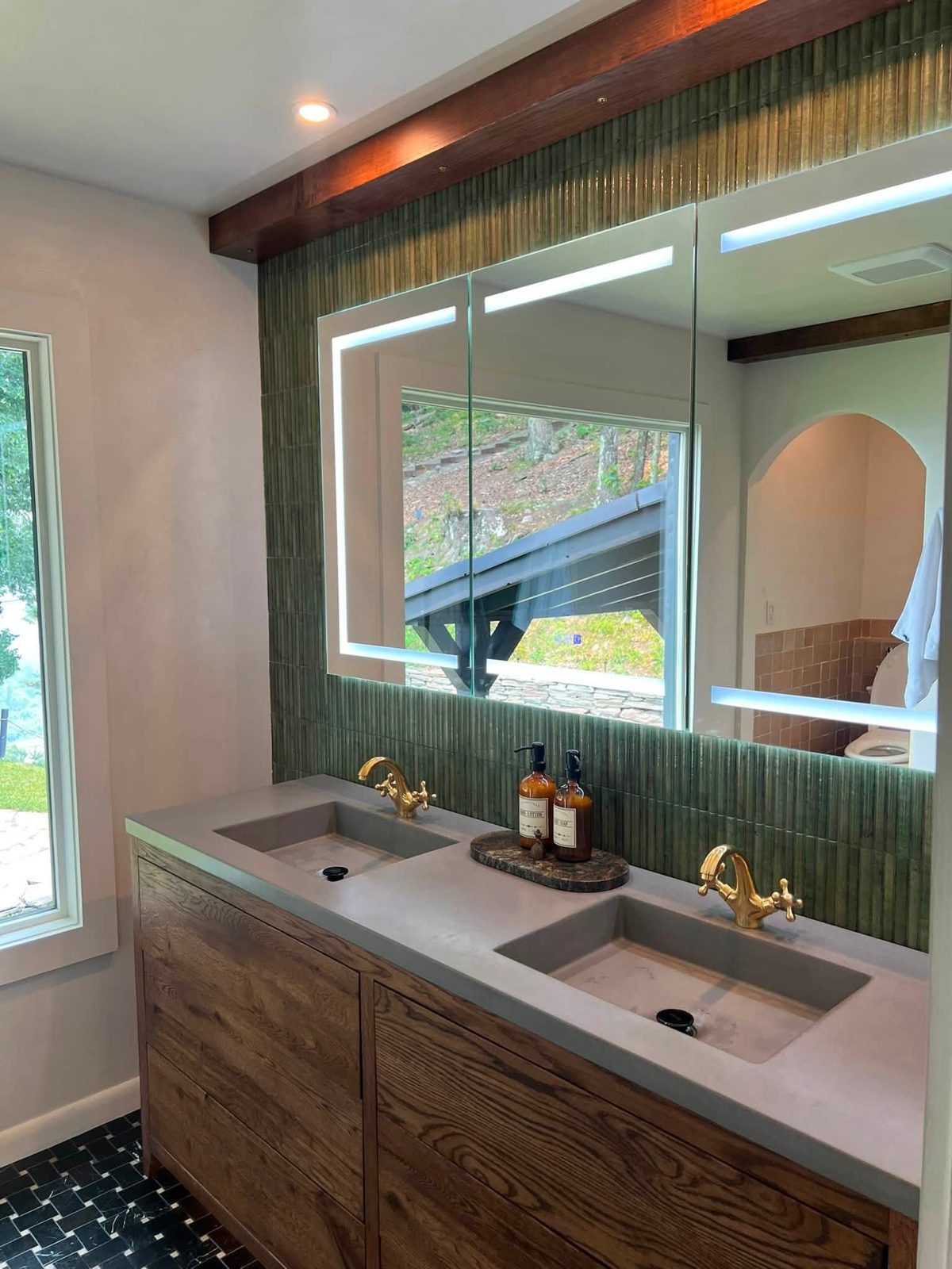 Double vanity with green fluted tile, concrete basins and brass taps